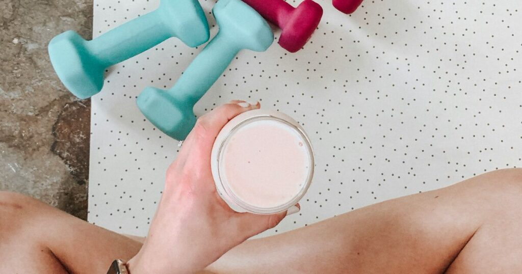 ダンベルと一緒にプロテインドリンクを飲むトレーニング後の休憩