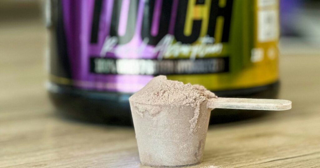 計量スプーンに入ったチョコレート味のプロテインパウダー